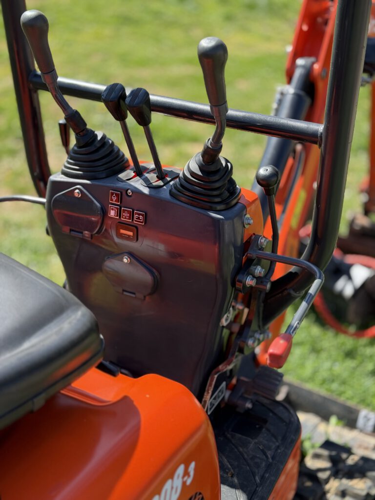 Joysticky a ovládací panel mini bagru Kubota K008-3 pro snadné a přesné řízení stroje.